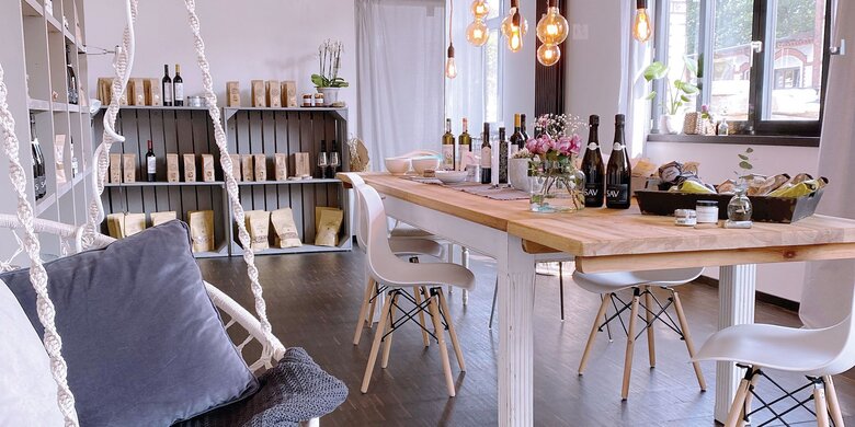 Innenaufnahme eines stilvollen Flavourique Showrooms mit gedecktem Tisch, Weinflaschen und Feinkost.